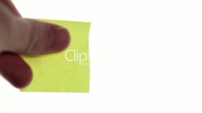 Man's hand put blank yellow sticker isolated on a white background. Ready for your inscription.