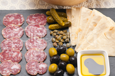 cold cut platter with pita bread and pickles