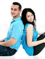 Man and woman sitting on ground and look at the camera