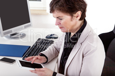 Businesswoman in office with tablet PC