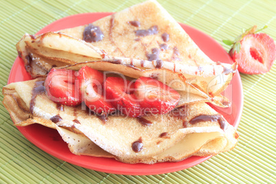 pancakes with strawberries on red plate