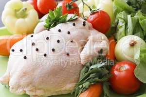 Whole raw chicken with vegetables and pepper