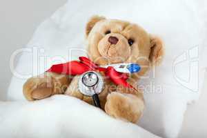Teddy is with clinical thermometer in bed