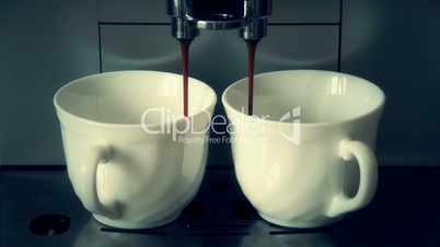 coffee machine pouring espresso in two cups