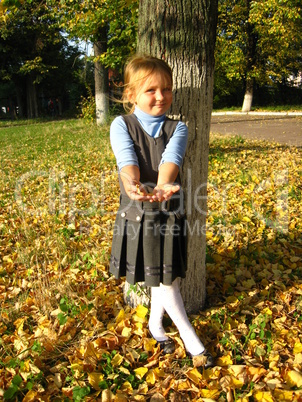 little girl with yellow leaf in autumn