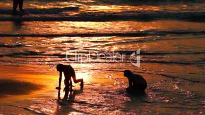 Two Kids Playing on the Beach at Sunset