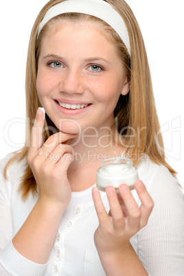 Cheerful young girl applying moistuizer face cream