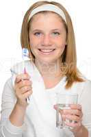 Young girl holding toothbrush glass water brushing