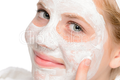 Young smiling girl applying cleaning facial mask