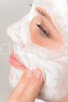 Fingers applying face mask moisturizer young girl