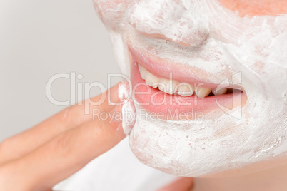 Smiling girl putting facial mask fingers cleaning
