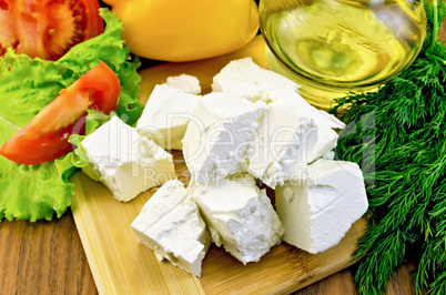 Feta cheese on the board with vegetables and oil