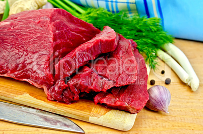 Meat beef on a wooden board with a knife