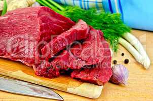 Meat beef on a wooden board with a knife