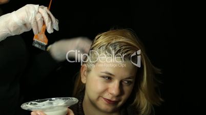 Female hairdresser bleaching hair