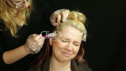 Woman at hairdresser coloring hair