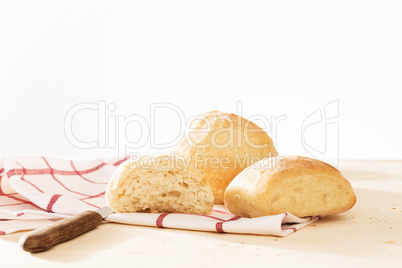 bauernbrötchen mit geschirrtuch und brotmesser