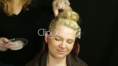 Woman at hairdresser coloring hair
