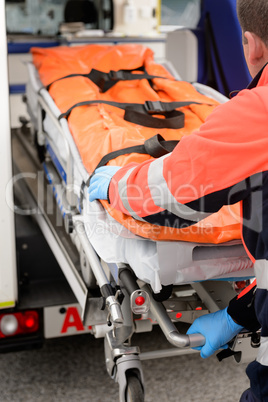 Paramedic rolling out gurney from emergency truck