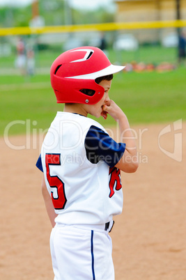 Little league player on base.
