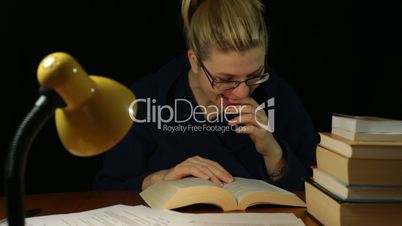 Happy woman reading book at night