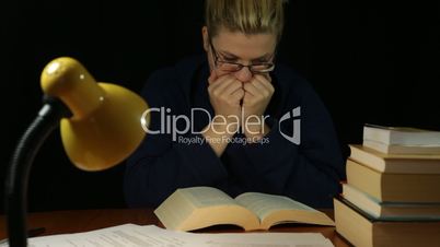Scared woman reading book at night