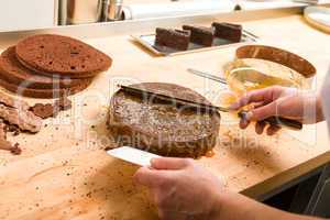 Cook spreading sauce on cake in kitchen