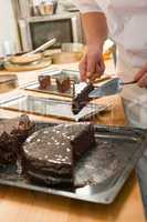 Confectioner cutting a slice of chocolate cake