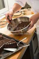 Chef decorating chocolate cake with icing sugar