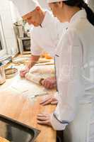 Male chef rolling dough with rolling pin