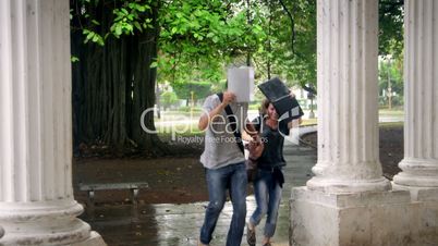 Students talking and smiling, man and woman running in the rain during storm