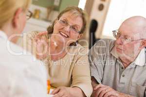 Doctor or Nurse Explaining Prescription Medicine to Senior Coupl