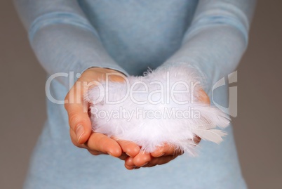 hand holding white feathers