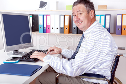 Man sitting in a wheelchair at the desk