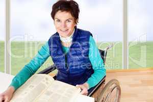 Woman with book sitting in a wheelchair at the table