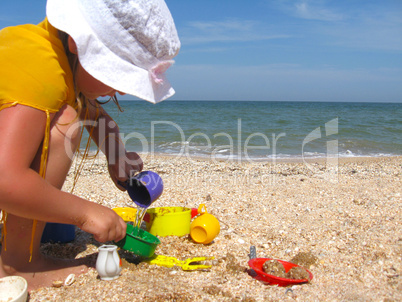 little girl plays at the sea