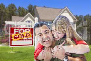 Couple in Front of Sold Real Estate Sign and House