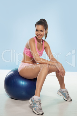 smiling woman sitting on a gym ball