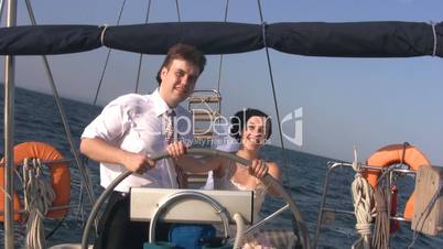 Young couple for yacht steering wheel