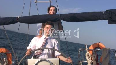 Young couple for yacht steering wheel