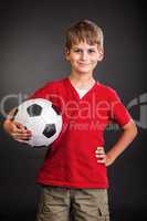Cute boy is holding a football ball. Soccer ball