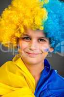 Football fan with  ukrainian flag on a black background