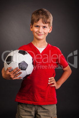 Cute boy is holding a football ball. Soccer ball