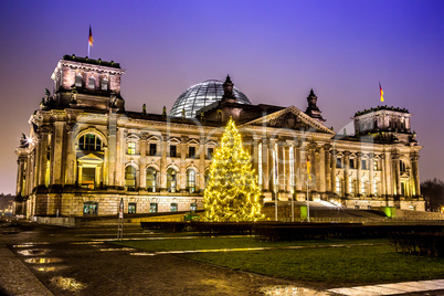 reichstag in berlin in winter at night with christmas tree