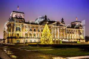 reichstag in berlin in winter at night with christmas tree