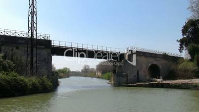 Vessel sails on the canal under the bridge in town