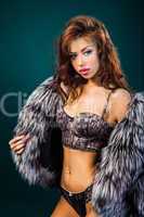 Attractive woman in fur coat and bra