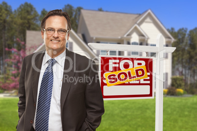 Male Real Estate Agent in Front of Sold Sign and House