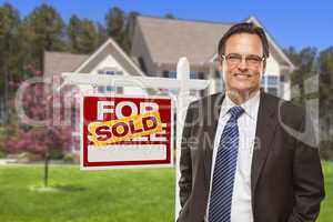 Male Real Estate Agent in Front of Sold Sign and House