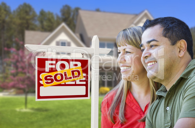 Couple in Front of Sold Real Estate Sign and House